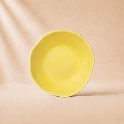 Yellow ceramic bowl on a beige background