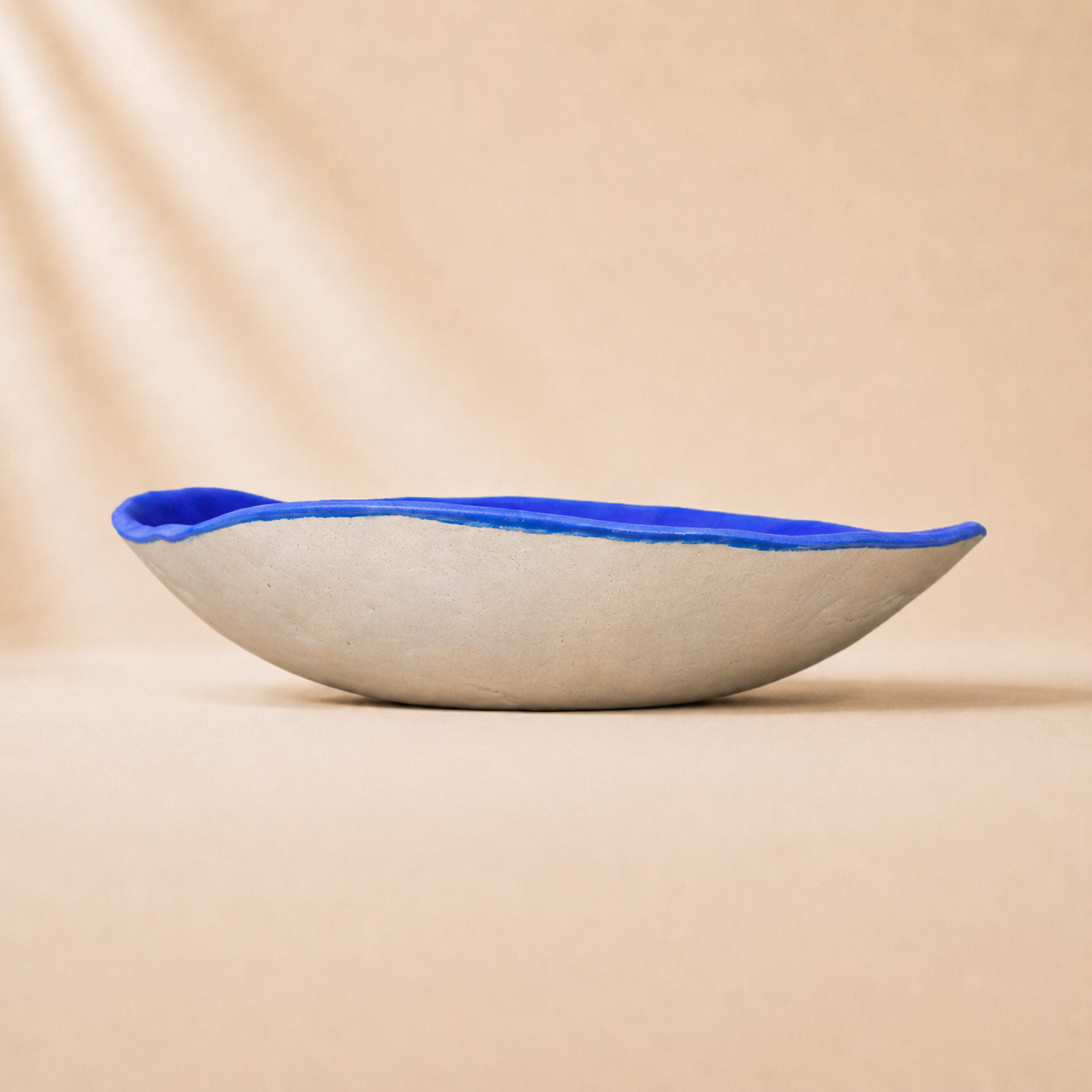 Ceramic bowl with blue rim on a beige background
