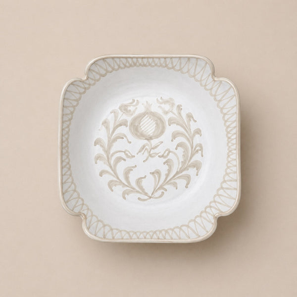 Decorative white plate with intricate patterns on a beige background