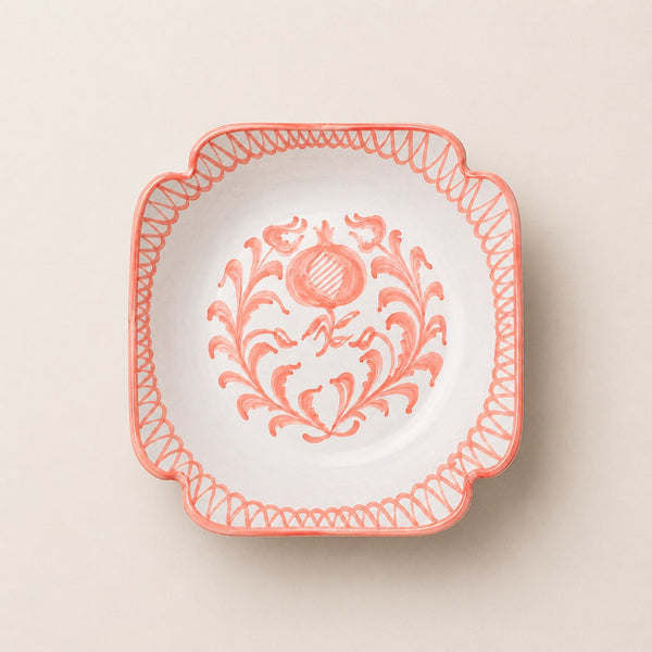 Decorative plate with floral design and coral rim on a beige background