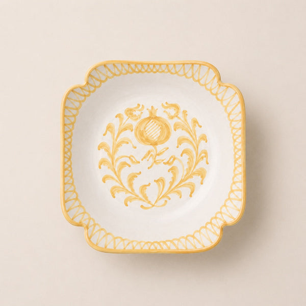 Decorative plate with gold floral design on a beige background