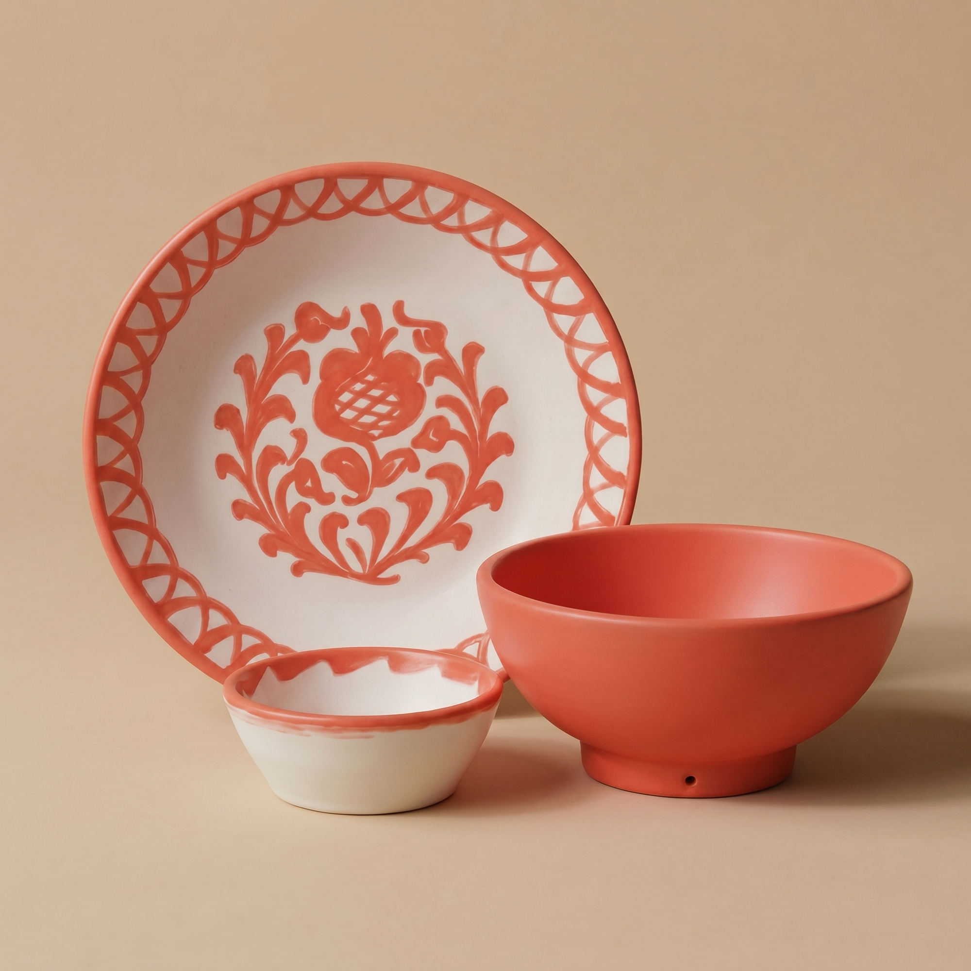 Coral Ceramic plate, bowl, and small dish with decorative patterns on a beige background