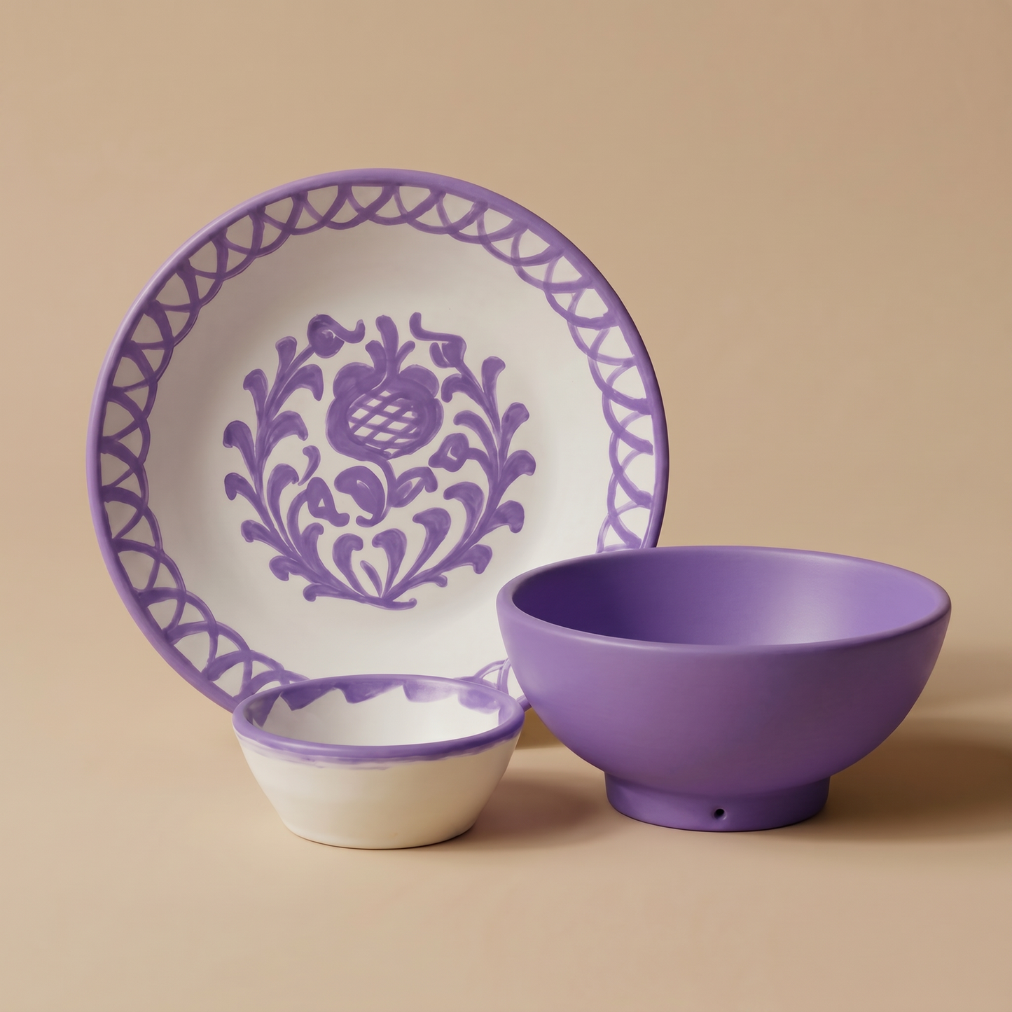 Ceramic plate, bowl, and small dish with lilac floral patterns on a beige background