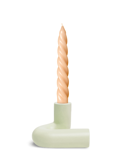 A twisted beige candle stands upright in OCTAEVO’s Templo Candle Holder, in Light Mint L-shaped chamberstick.