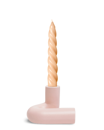 A twisted beige candle in Pink OCTAEVO Templo Candle Holder sits against a plain white background.