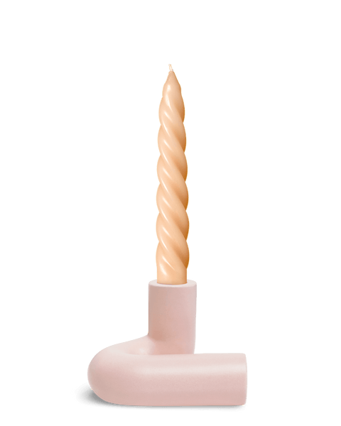 A twisted beige candle in Pink OCTAEVO Templo Candle Holder sits against a plain white background.