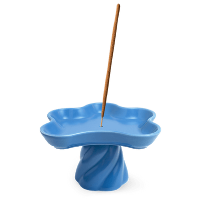 The Templo Incense Holder by OCTAEVO is a blue, flower-shaped stoneware piece with an upright incense stick.
