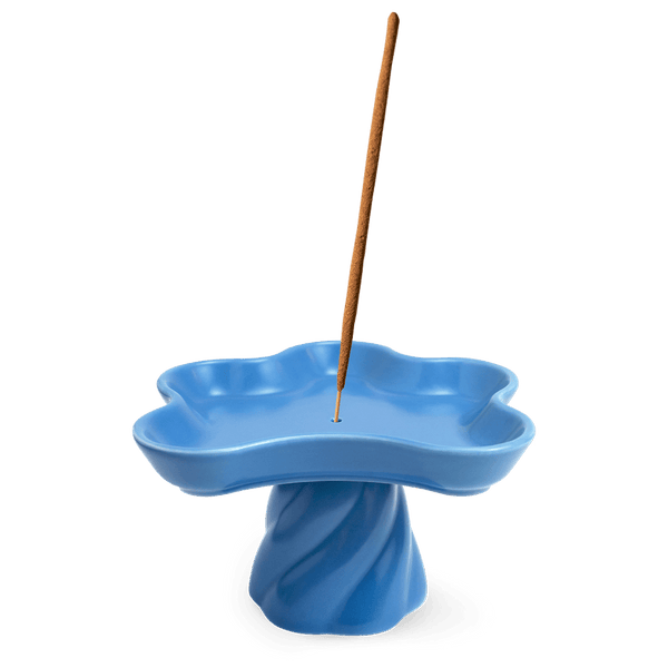The Templo Incense Holder by OCTAEVO is a blue, flower-shaped stoneware piece with an upright incense stick.