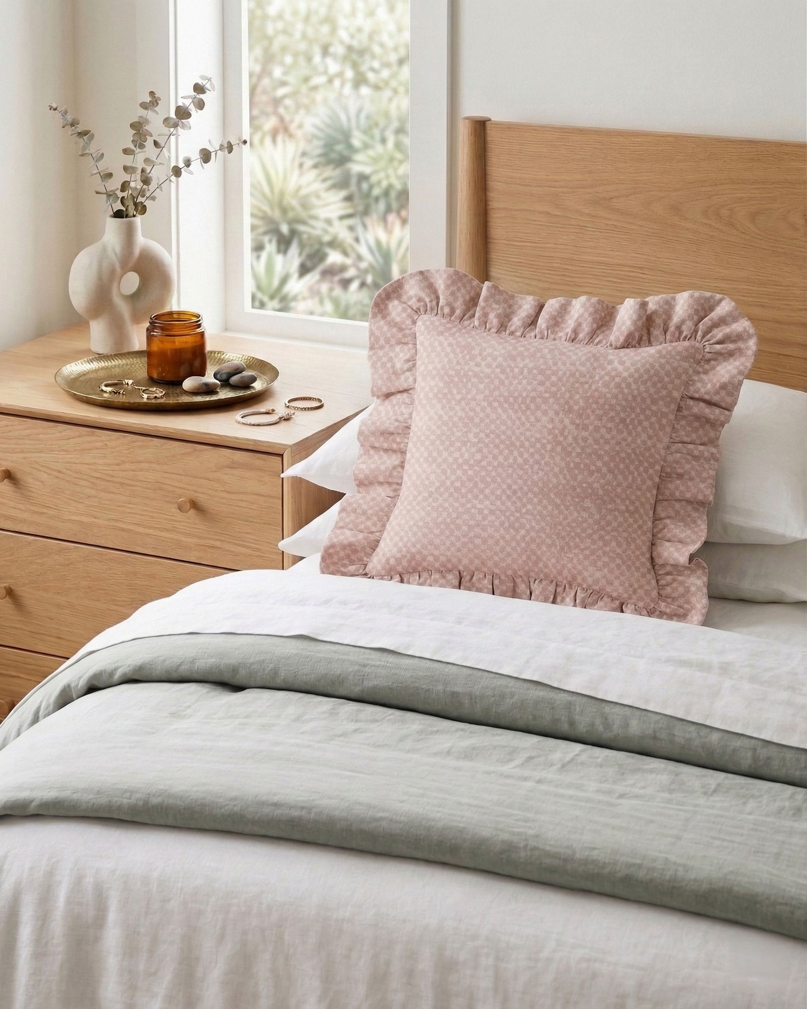 Modern pastel bedroom decor with ruffled linen cushion in pink