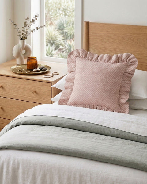 Modern pastel bedroom decor with ruffled linen cushion in pink