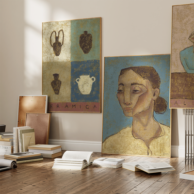 three art prints on a floor filled with books 