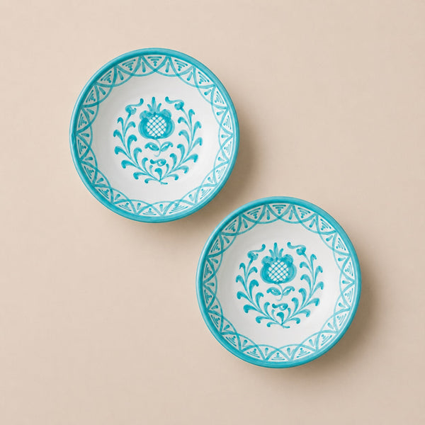 Two turquoise and white decorative plates on a beige background