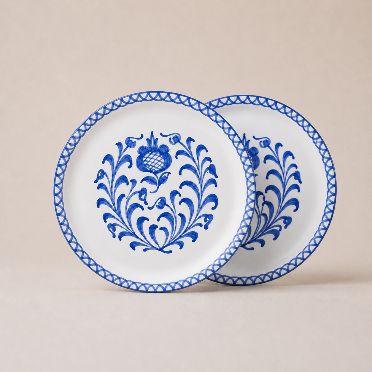 Two white plates with blue floral patterns on a beige background