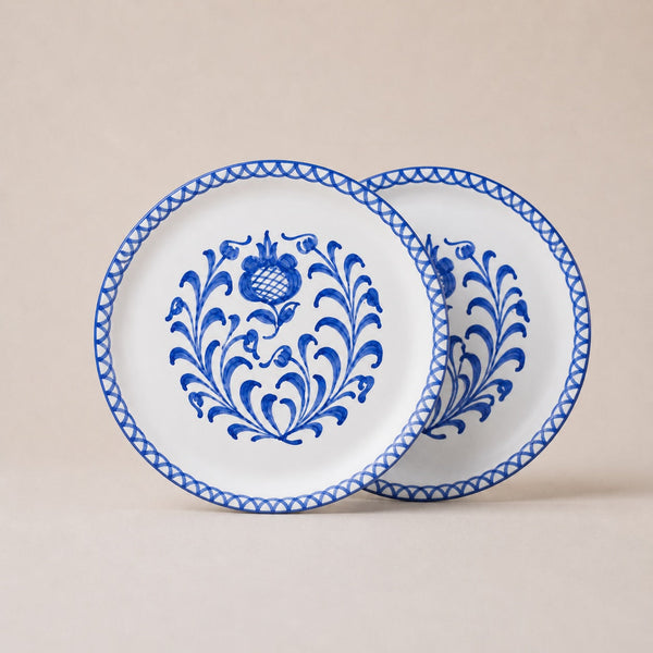 Two white plates with blue floral patterns on a beige background