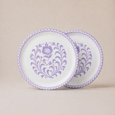 Two decorative plates with purple floral patterns on a beige background