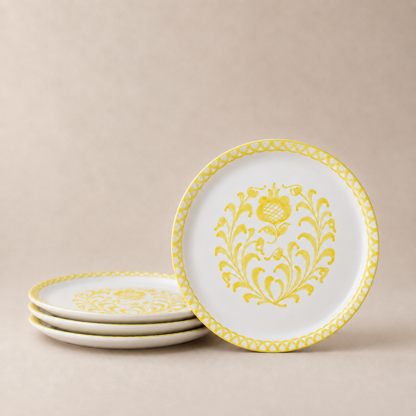 Set of white plates with yellow floral patterns on a beige background