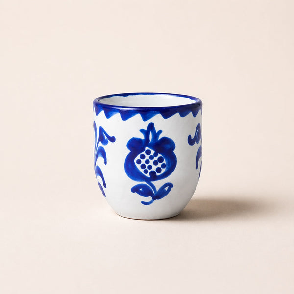 Ceramic cup with blue floral patterns on a beige background