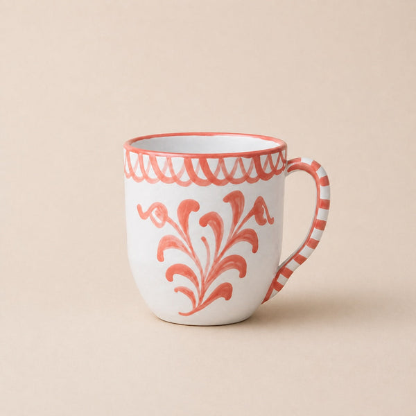 White mug with coral floral patterns on a beige background