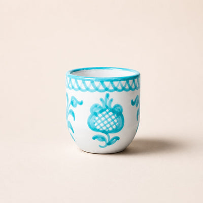 Ceramic cup with blue floral patterns on a beige background