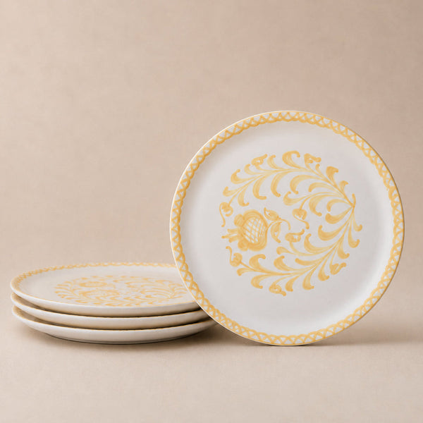 Set of white plates with gold decorative patterns on a beige background