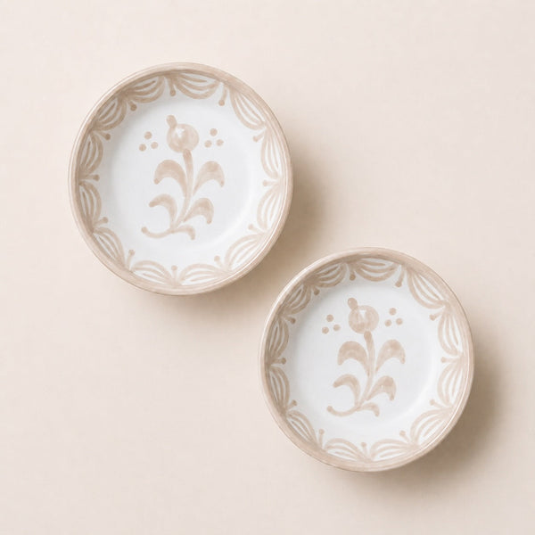 Two ceramic bowls with floral patterns on a beige background