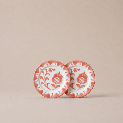 Two ceramic plates with floral patterns on a beige background