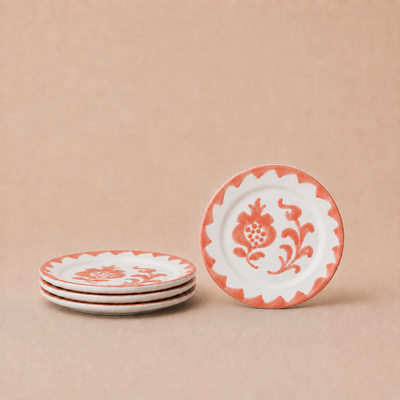 Set of four decorative plates with floral patterns on a beige background