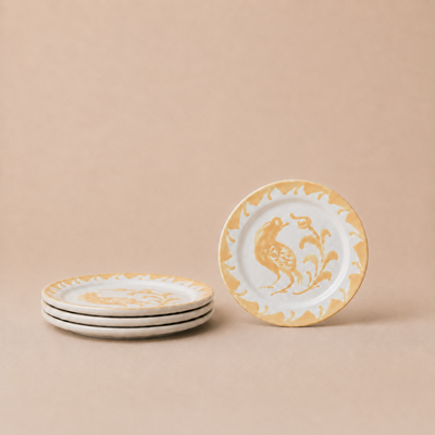 Set of ceramic plates with gold and white design on a beige background