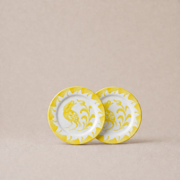 Two ceramic plates with yellow floral patterns on a beige background