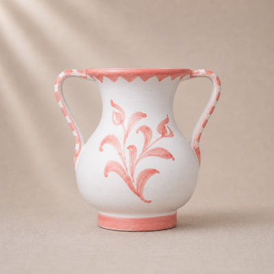 White ceramic vase with pink floral patterns on a beige background
