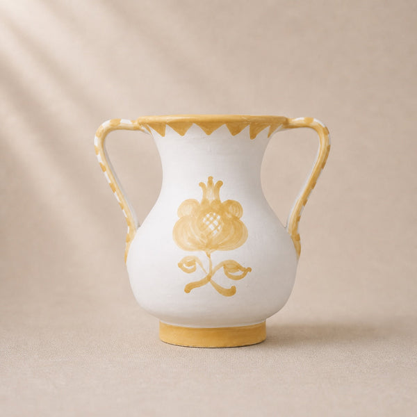 White vase with gold floral design and trim on a beige background