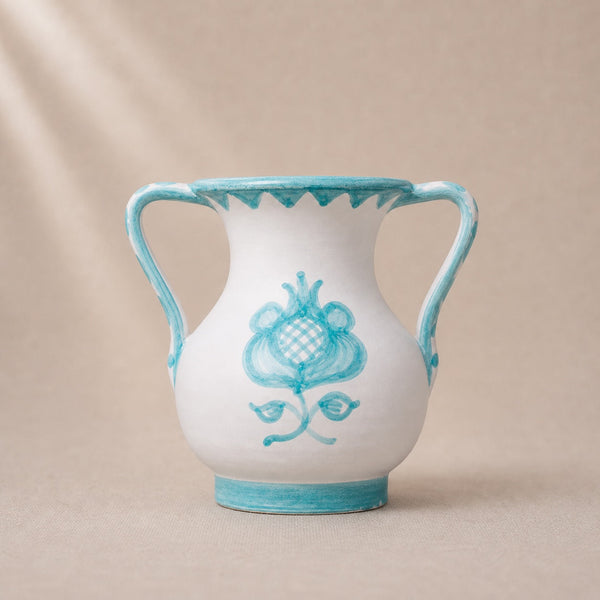 White vase with blue floral design and rim on a beige background