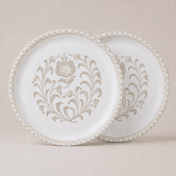 Two traditional dinner plates with intricate patterns on a beige background