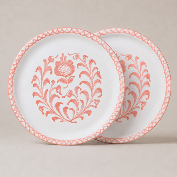 Two traditional dinner plates with pink floral patterns on a beige background