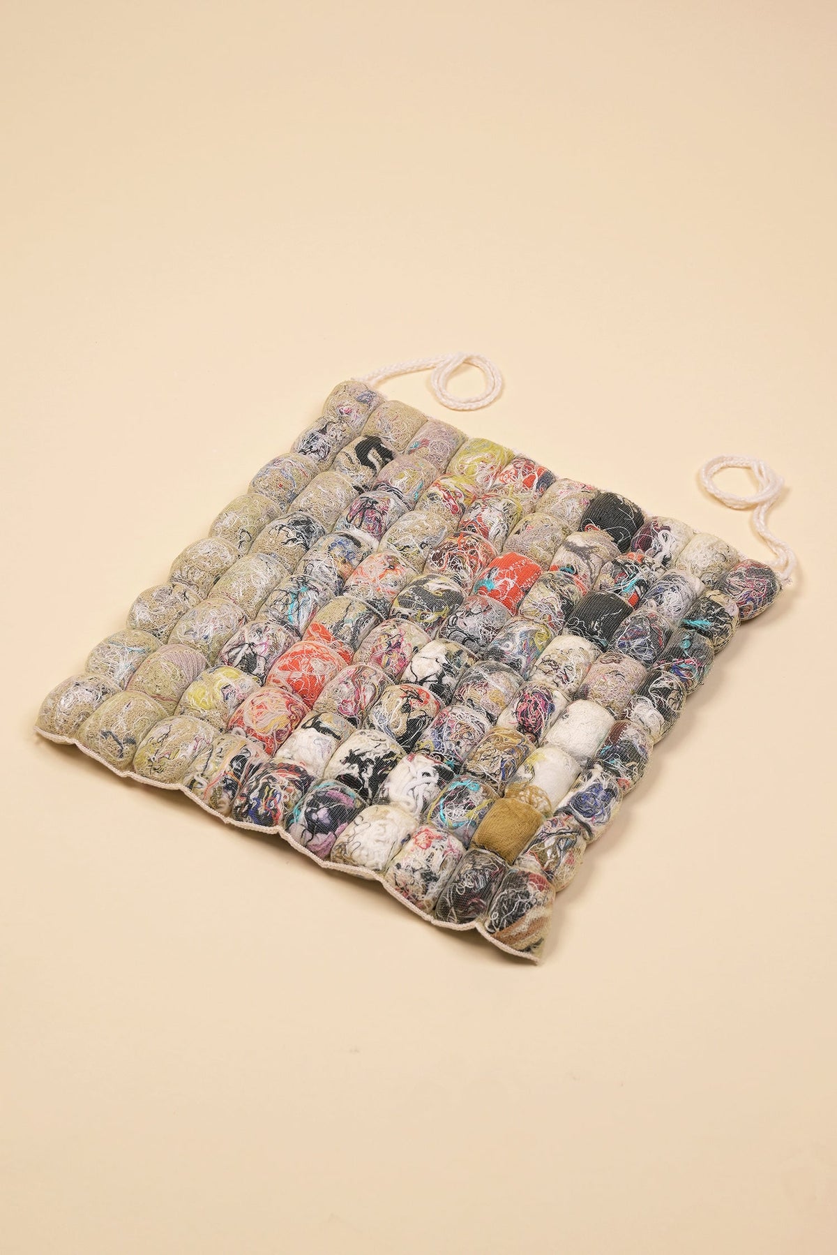 front view of knit seat cushion with transparent cover filled with upcycled materials