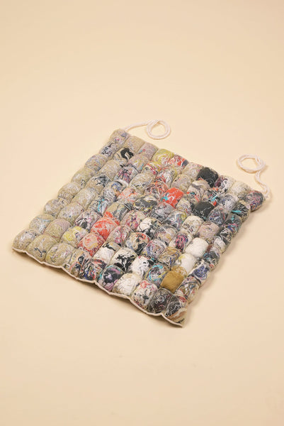 front view of knit seat cushion with transparent cover filled with upcycled materials