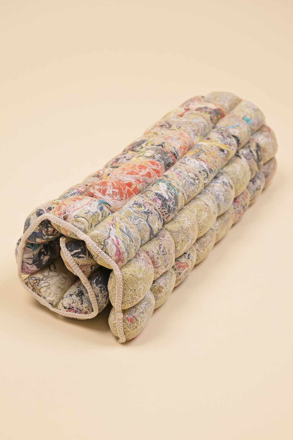 rolled up knit seat cushion with transparent cover filled with upcycled materials