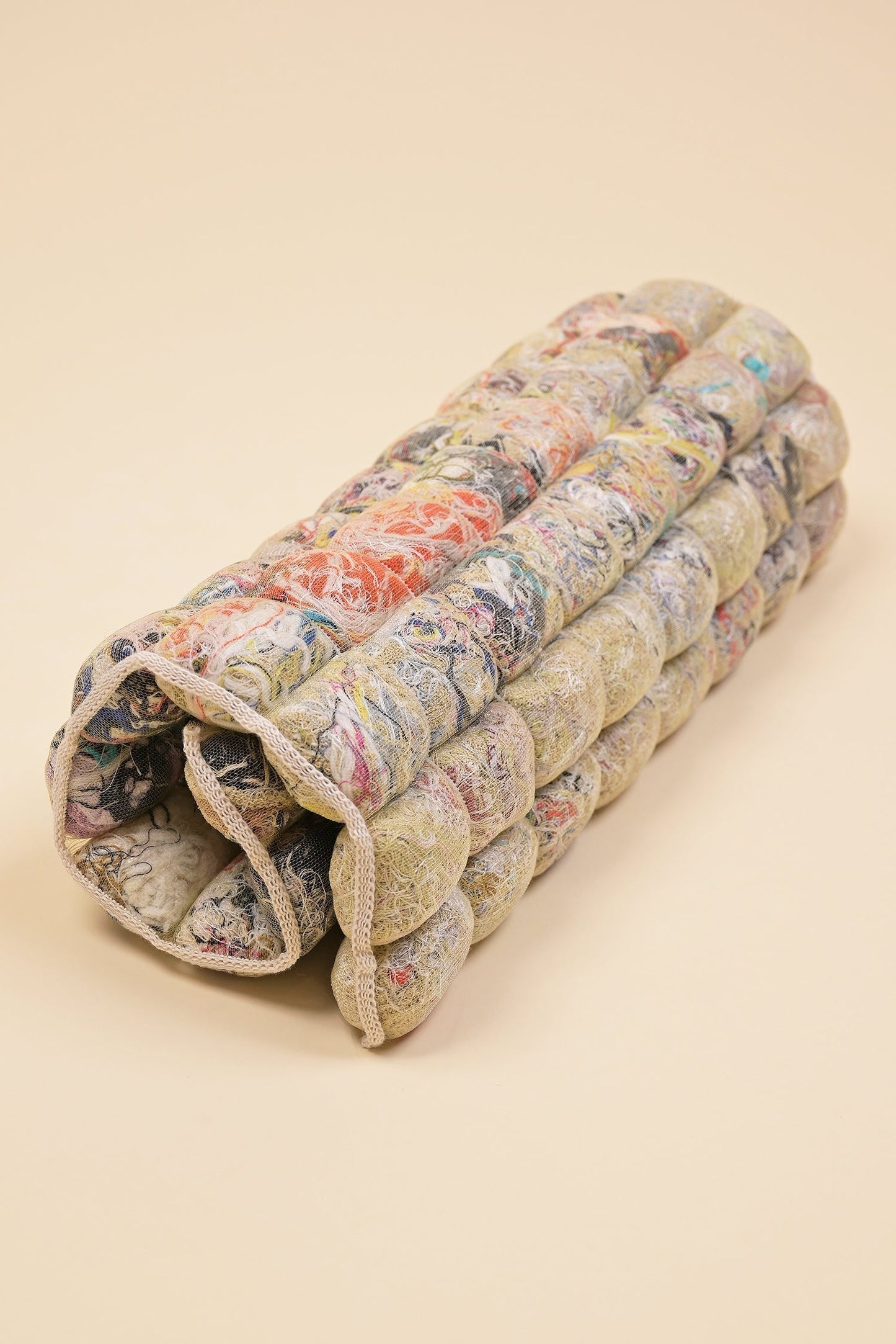 rolled up knit seat cushion with transparent cover filled with upcycled materials