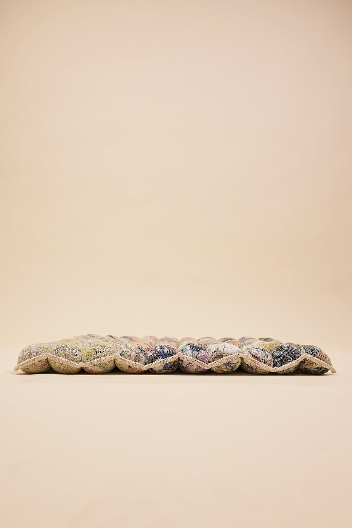 side view of knit seat cushion with transparent cover filled with upcycled materials