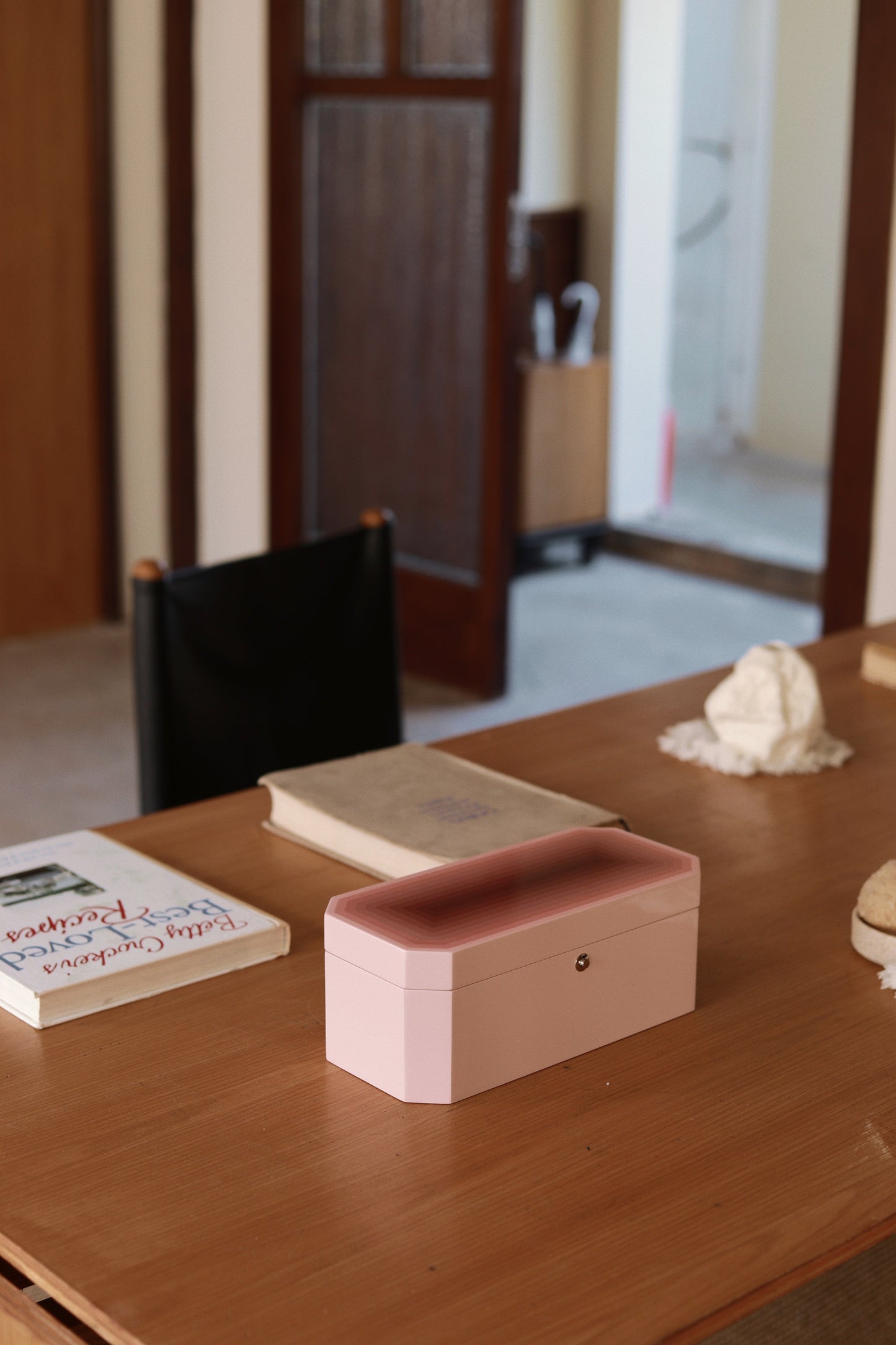 Vinidec Chiaroscuro octagonal jewellery and watch box in peach gradient lacquer, styled on a wooden dining table with books