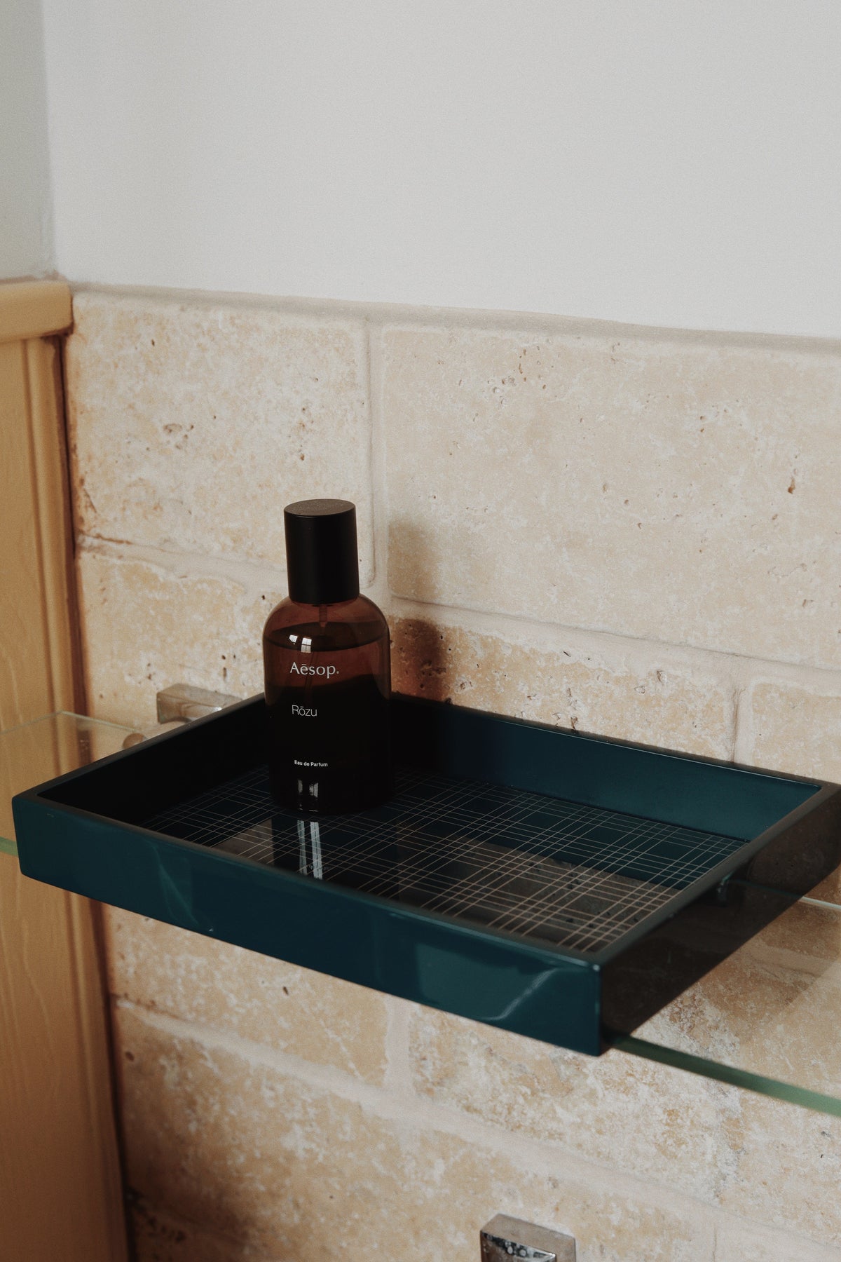 Vinidec wide linear lacquered tray with grid insert styled with folded guest hand towels and perfume on a stone bathroom vanity