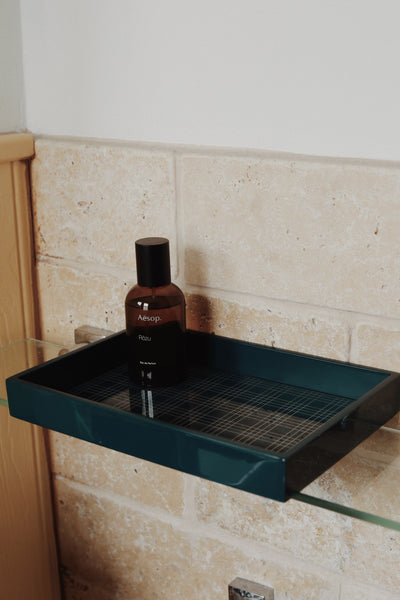 Vinidec wide linear lacquered tray with grid insert styled with folded guest hand towels and perfume on a stone bathroom vanity