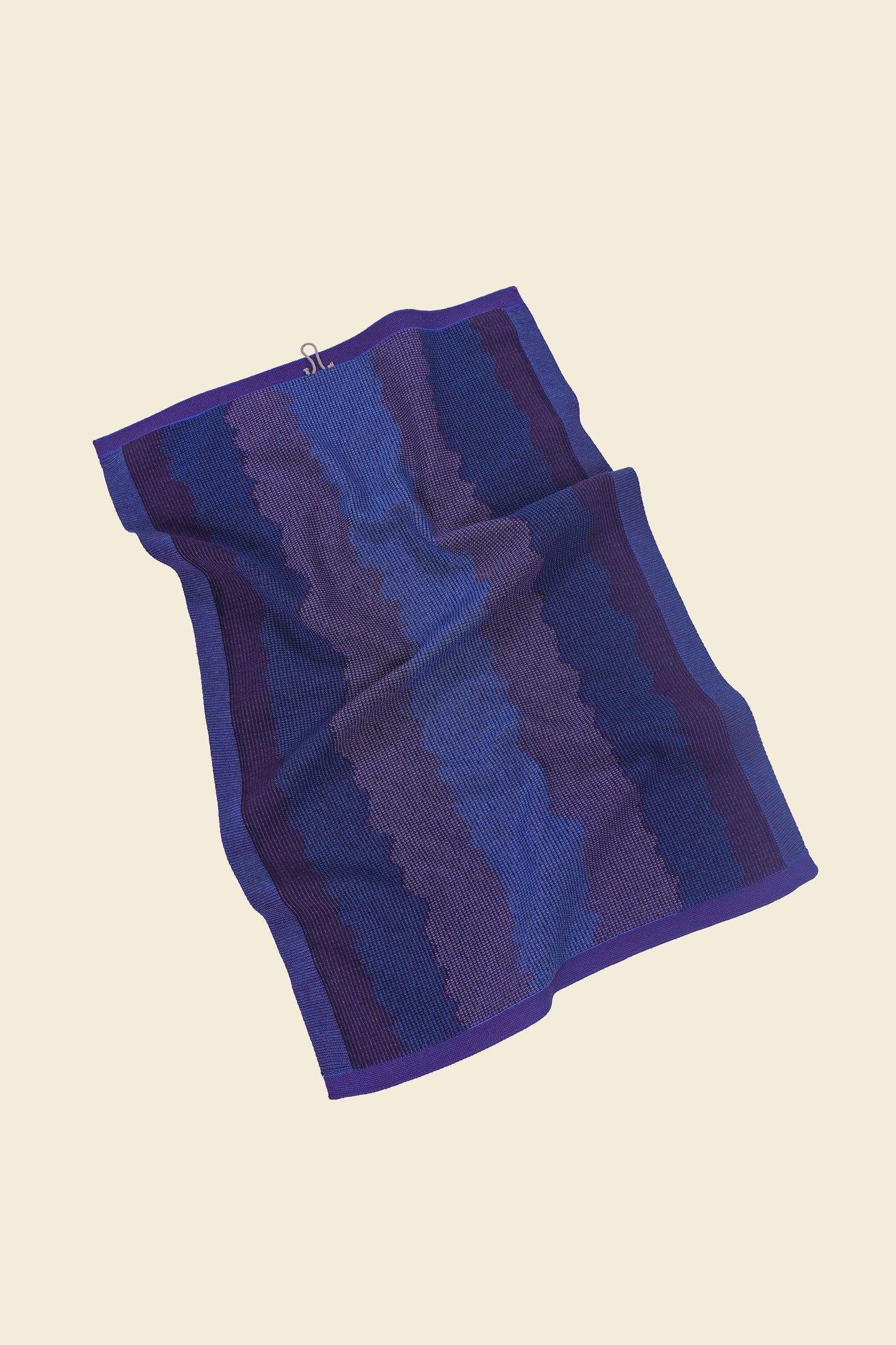 back view of purple knit organic cotton kitchen towel with wavy pattern with folds