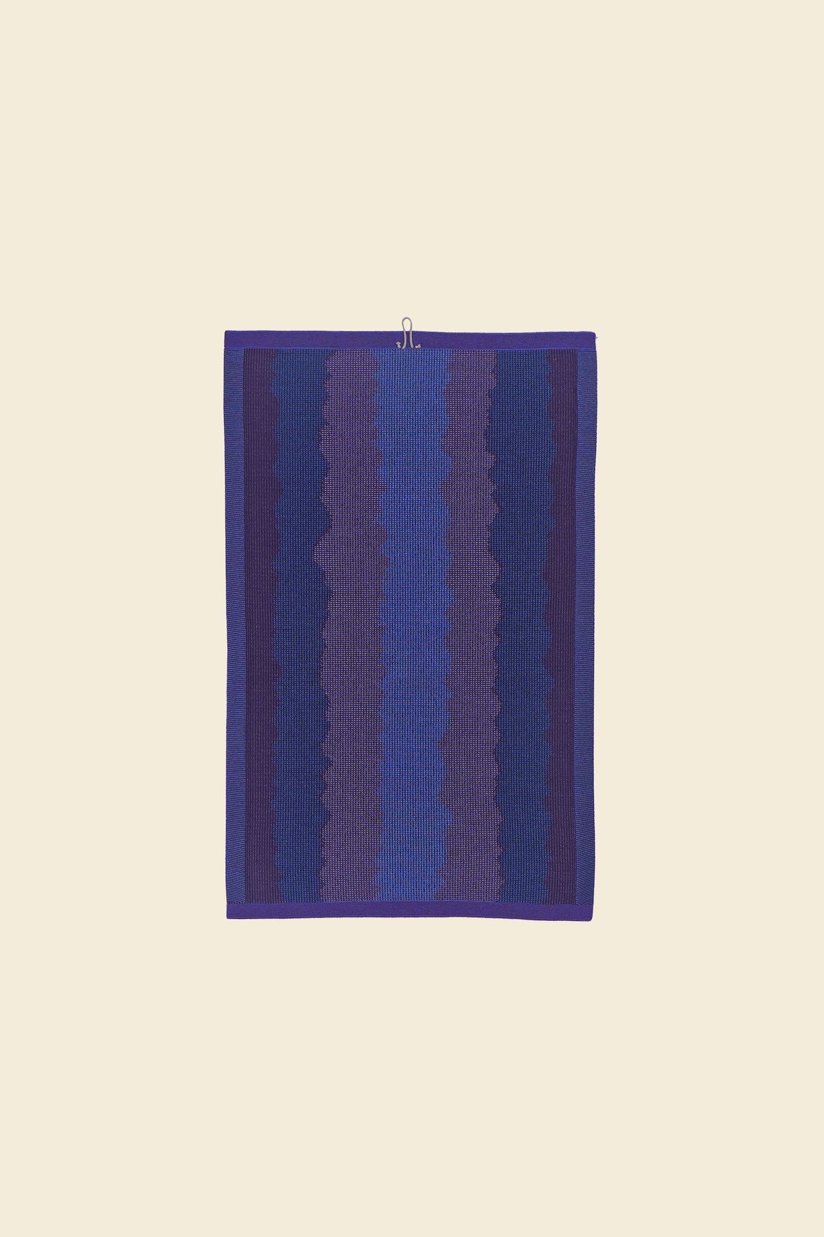 back view of purple knit organic cotton kitchen towel with wavy pattern