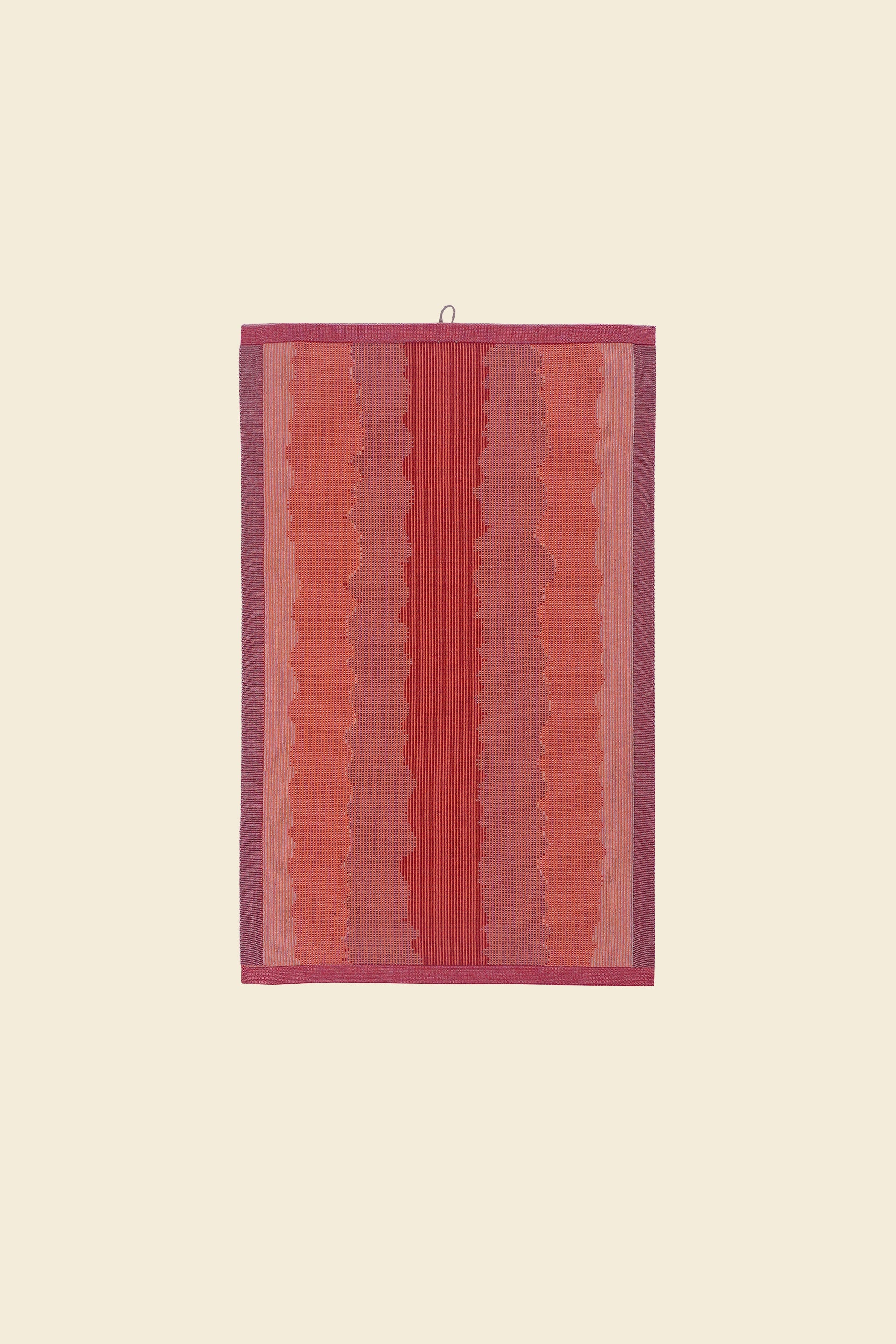 front view of red knit organic cotton kitchen towel with wavy pattern