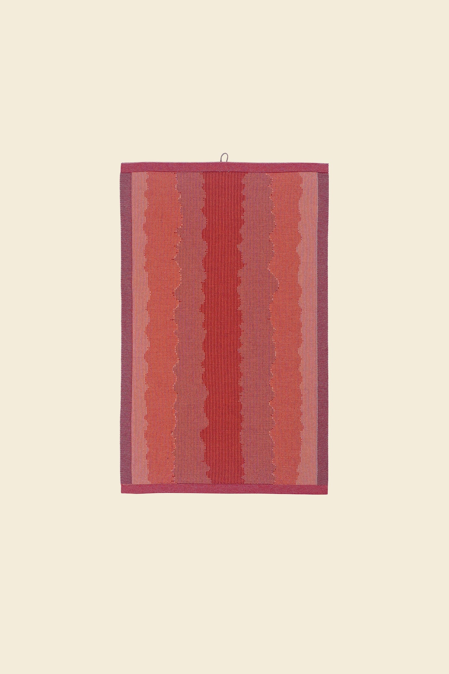 front view of red knit organic cotton kitchen towel with wavy pattern