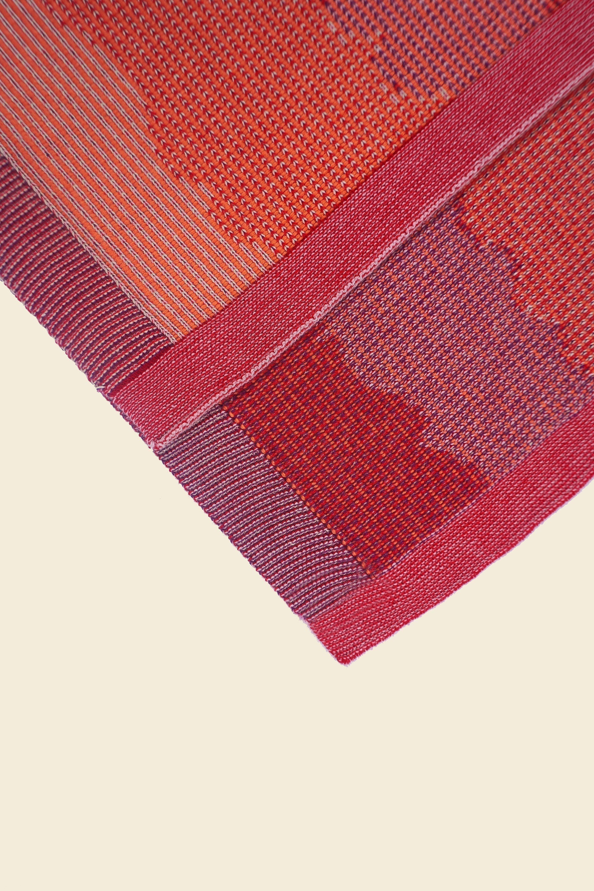 corner of red knit organic cotton kitchen towel set with wavy pattern