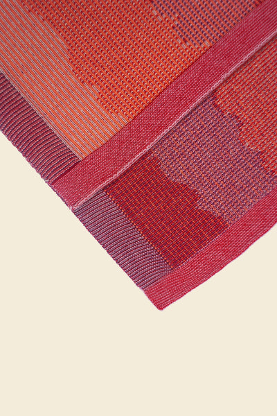 corner of red knit organic cotton kitchen towel set with wavy pattern