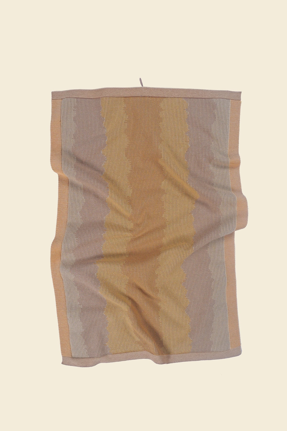front view of yellow knit organic cotton kitchen towel with wavy pattern with folds