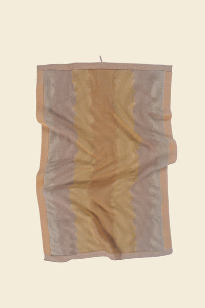 front view of yellow knit organic cotton kitchen towel with wavy pattern with folds